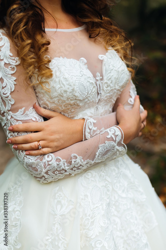 close-up of wedding dress on the bride who embrace himself