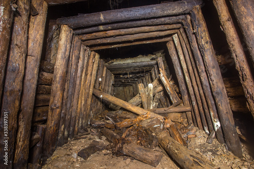 Fototapeta Naklejka Na Ścianę i Meble -  Underground abandoned bauxite ore mine tunnel with collapsed wooden timbering