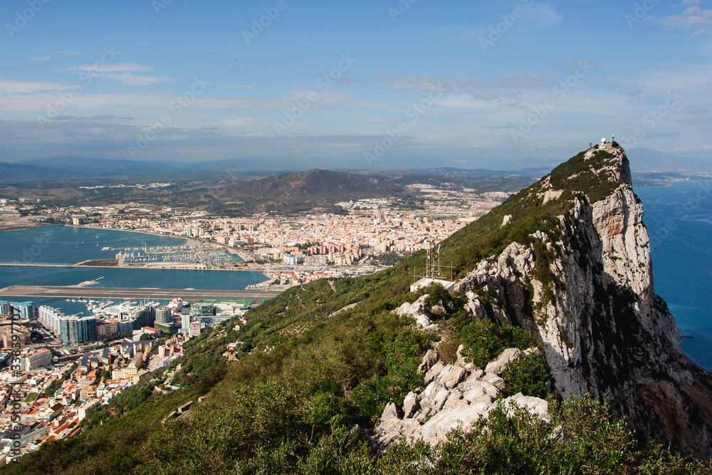 Rock of Gibraltar top view. High mountain over the sea. Sunny cityscape background. British territory landscape. Harbour coastal city panoramic view.