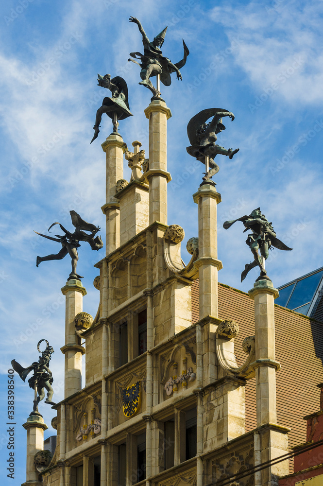 On top of the stepped gable of the Masons Guild Hall. six dancers turn merrily with the wind in Ghent, Belgium