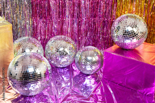 Shiny Disco balls on the floor with colourful paper hangings and cellophane refelective paper backdrop for fancy party theme photo