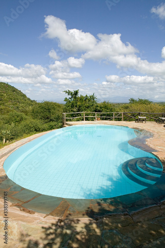 Swimming pool with turquoise water surrounded by the hills of North Kenya  Africa at the Lewa Wildlife Conservancy