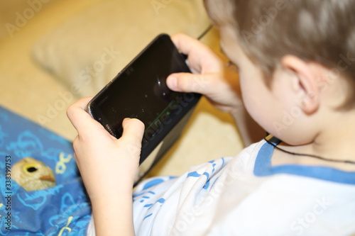 boy playing games on the phone, modern children's dependence on gadgets