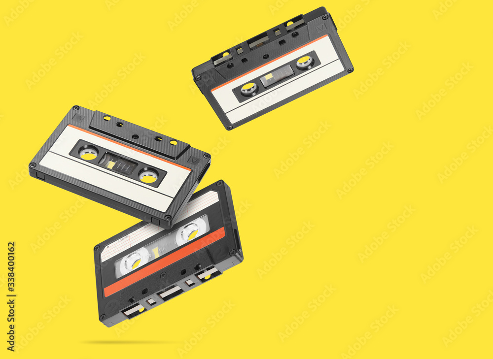 Fototapeta premium Old audio tape compact cassette isolated on yellow background