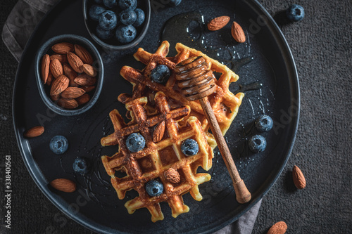 Closeup of waffles with blueberries, honey and almont photo