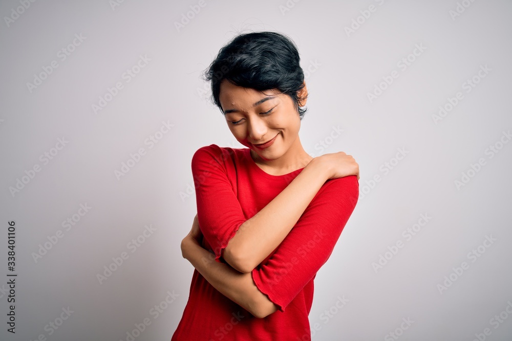 Young beautiful asian girl wearing casual red t-shirt standing over isolated white background Hugging oneself happy and positive, smiling confident. Self love and self care Young beautiful asian girl wearing casual red t-shirt standing over isolated white background Hugging oneself happy and positive, smiling confident. Self love and self care