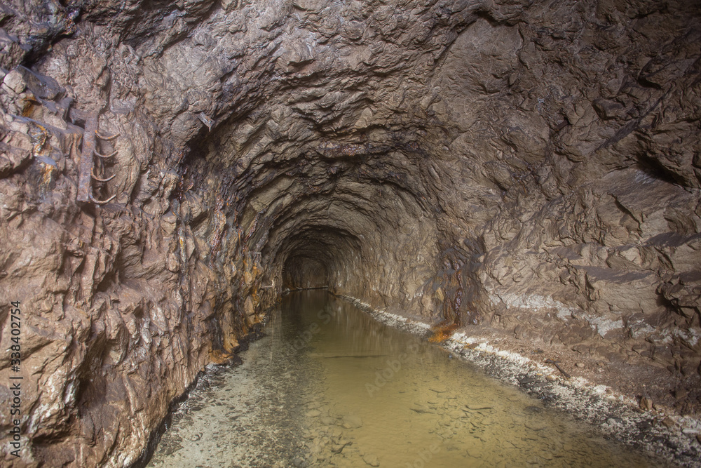 Naklejka premium Underground abandoned bauxite ore mine tunnel with water