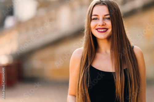 young woman with bright makeup and freckles in black dress cute