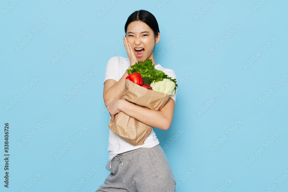 young woman holding a basket full of vegetables young woman holding a basket full of vegetables