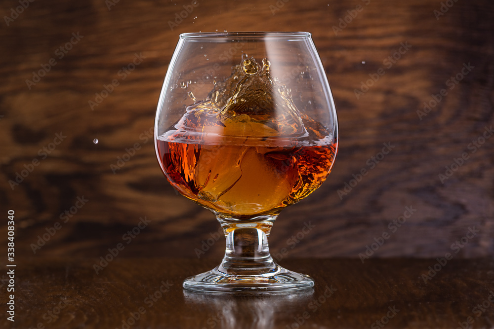 Splash in cognac glass from falling ice Splash in cognac glass from falling ice