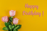 Pink roses on pastel yellow background. Birthday Day concept.