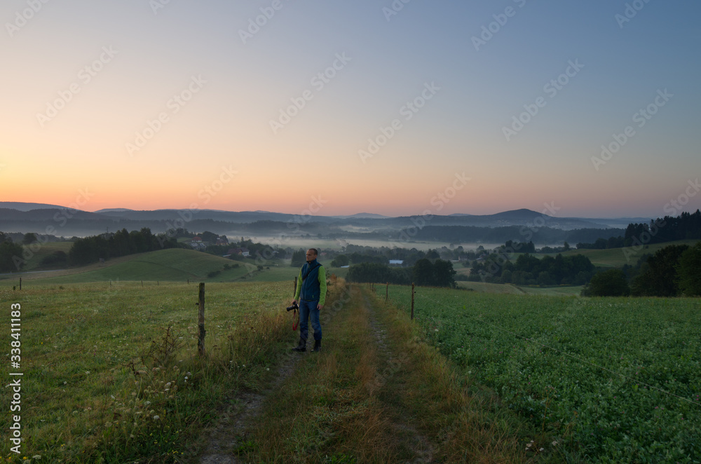 photographer standing on a mountain road on an autumn morning