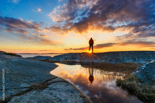 Man standing and enjoying sunset at the coastline. Stora Amundön, Sweden.