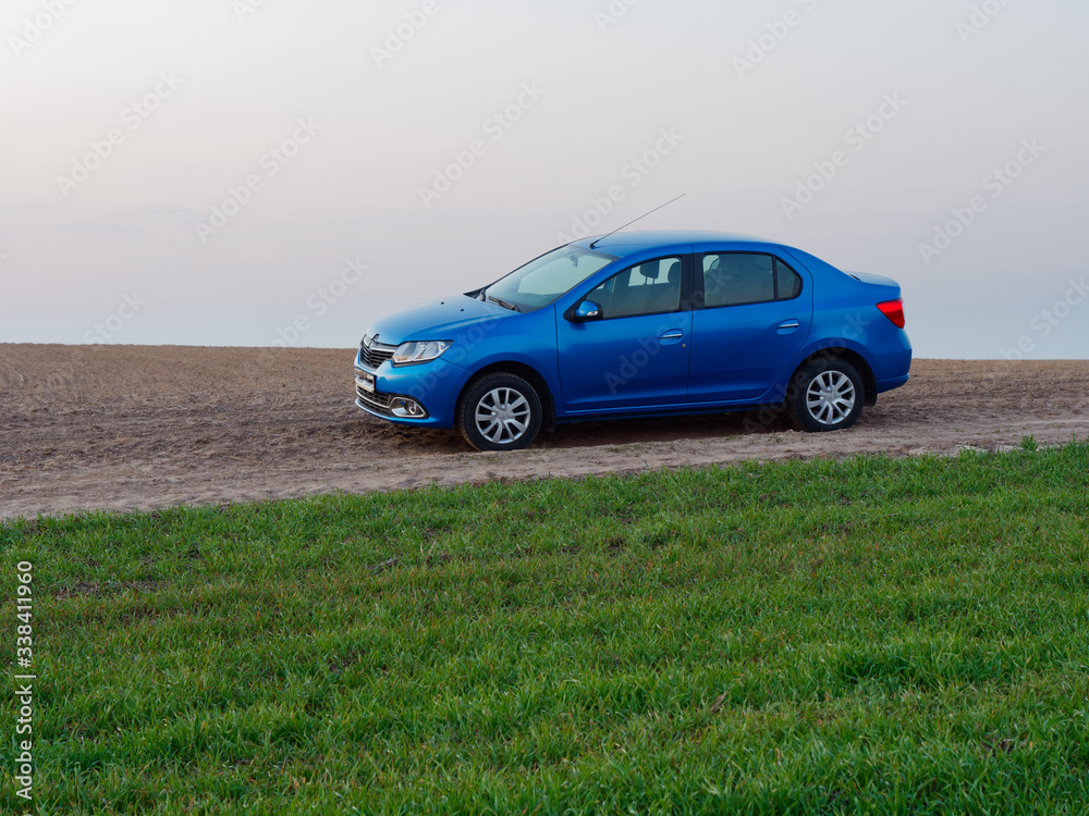 Belarus blue car in a field in spring at sunrise Belarus blue car in a field in spring at sunrise