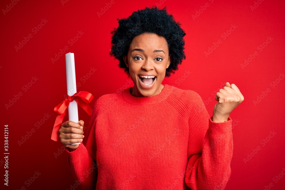 Young African American afro student woman with curly hair holding university degree diploma screaming proud and celebrating victory and success very excited, cheering emotion Young African American afro student woman with curly hair holding university degree diploma screaming proud and celebrating victory and success very excited, cheering emotion