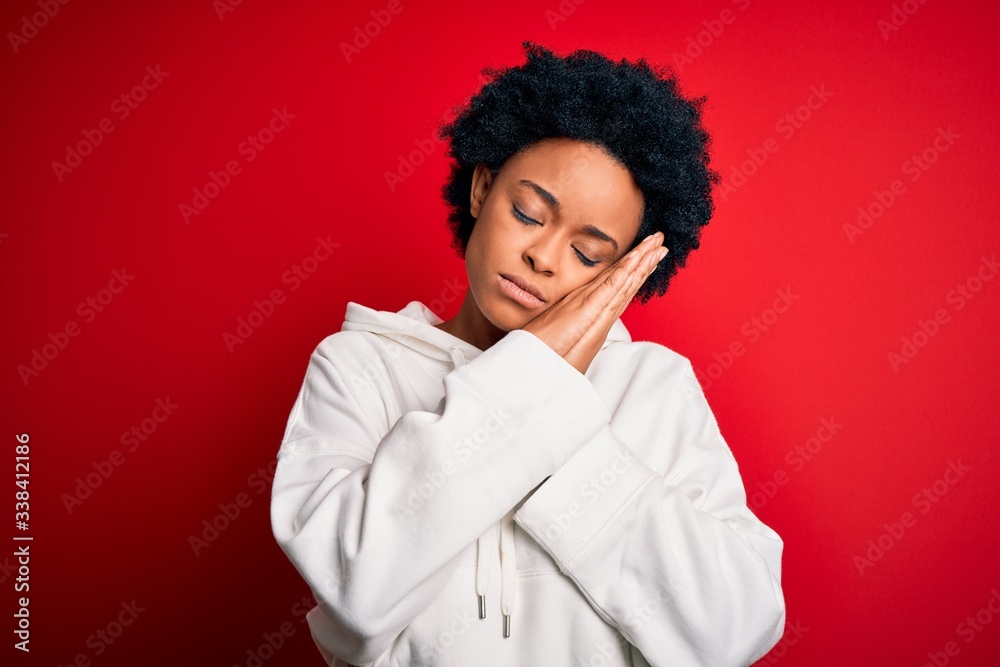 Young beautiful African American afro sportswoman with curly hair wearing sportswear sleeping tired dreaming and posing with hands together while smiling with closed eyes. Young beautiful African American afro sportswoman with curly hair wearing sportswear sleeping tired dreaming and posing with hands together while smiling with closed eyes.