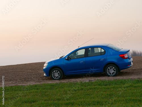 Belarus blue car in a field in spring at sunrise