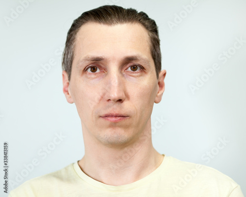 Portrait of a calm, balanced man, grey background, emotions series.
