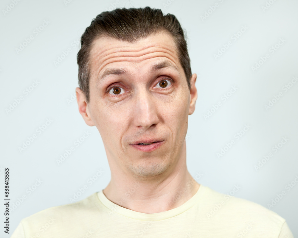 Obraz premium Portret mężczyzny zaskoczony, szare tło, seria emocji.