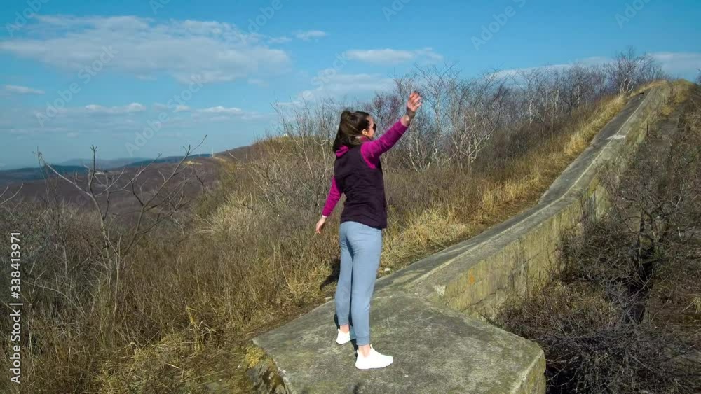 athletic girl doing exercises in the woods. shooting with a quadrocopter, flying around the girl while she does exercises athletic girl doing exercises in the woods. shooting with a quadrocopter, flying around the girl while she does exercises