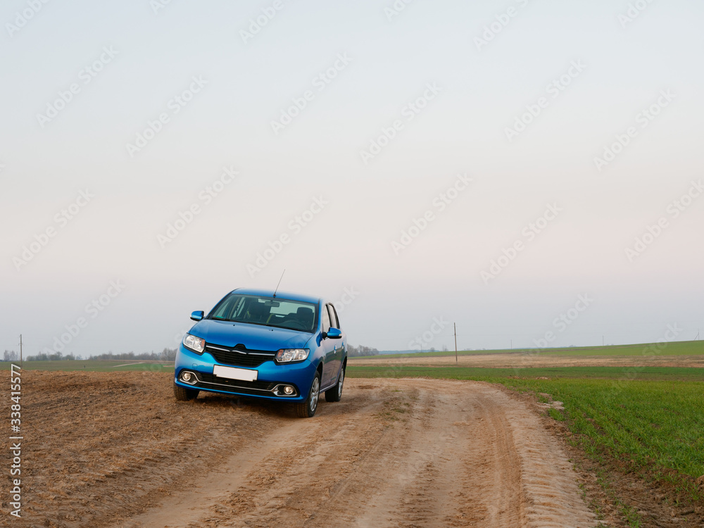 Belarus blue car in a field in spring at sunrise Belarus blue car in a field in spring at sunrise