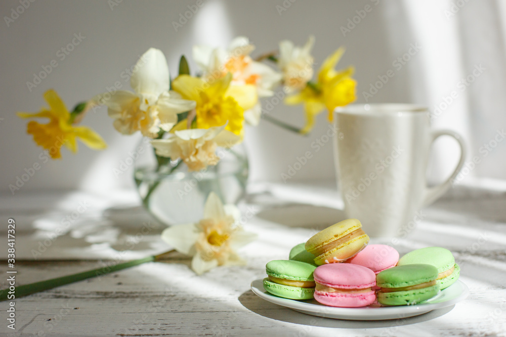 a Cup of tea with macaroons morning Breakfast with a bouquet of flowers in a vase a Cup of tea with macaroons morning Breakfast with a bouquet of flowers in a vase