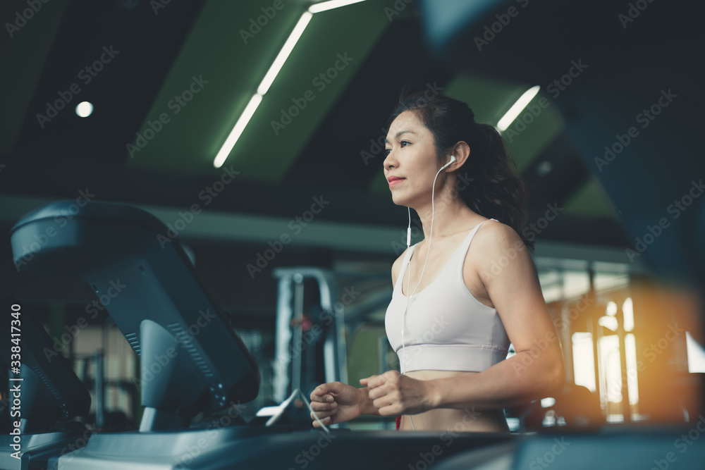 Young fitness woman on the treadmill in the gym.