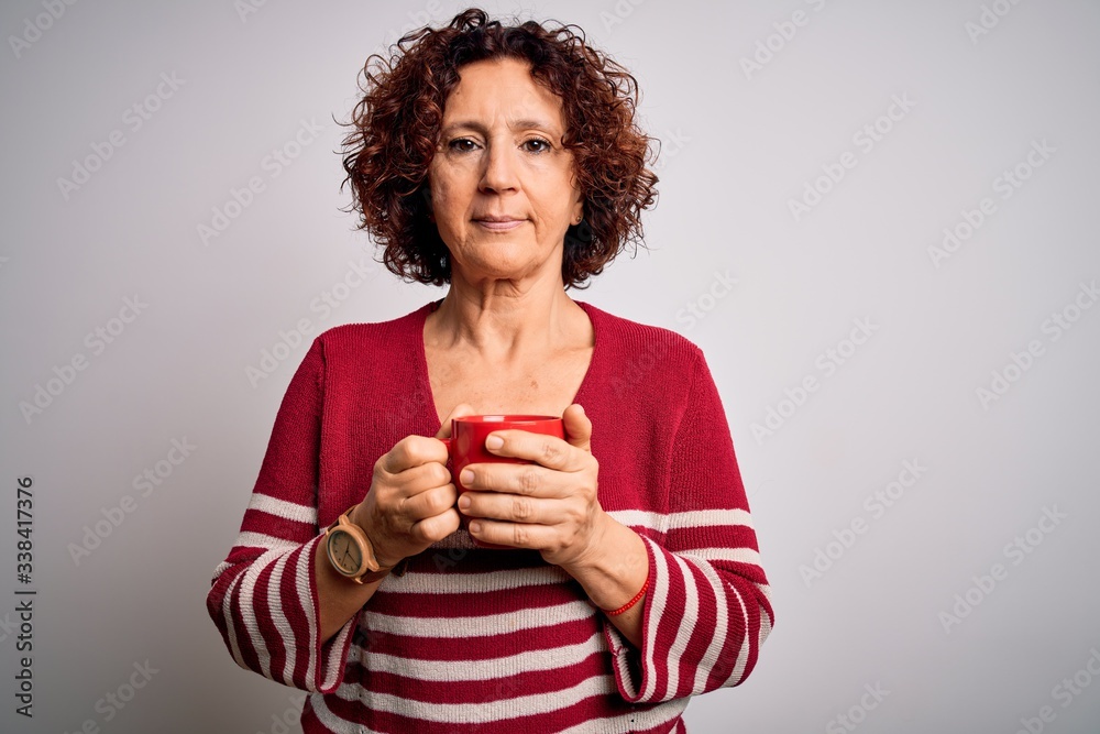 Middle age curly hair woman drinking mug of coffee over isolated white background with a confident expression on smart face thinking serious Middle age curly hair woman drinking mug of coffee over isolated white background with a confident expression on smart face thinking serious