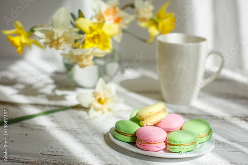a Cup of tea with macaroons morning Breakfast with a bouquet of flowers in a vase