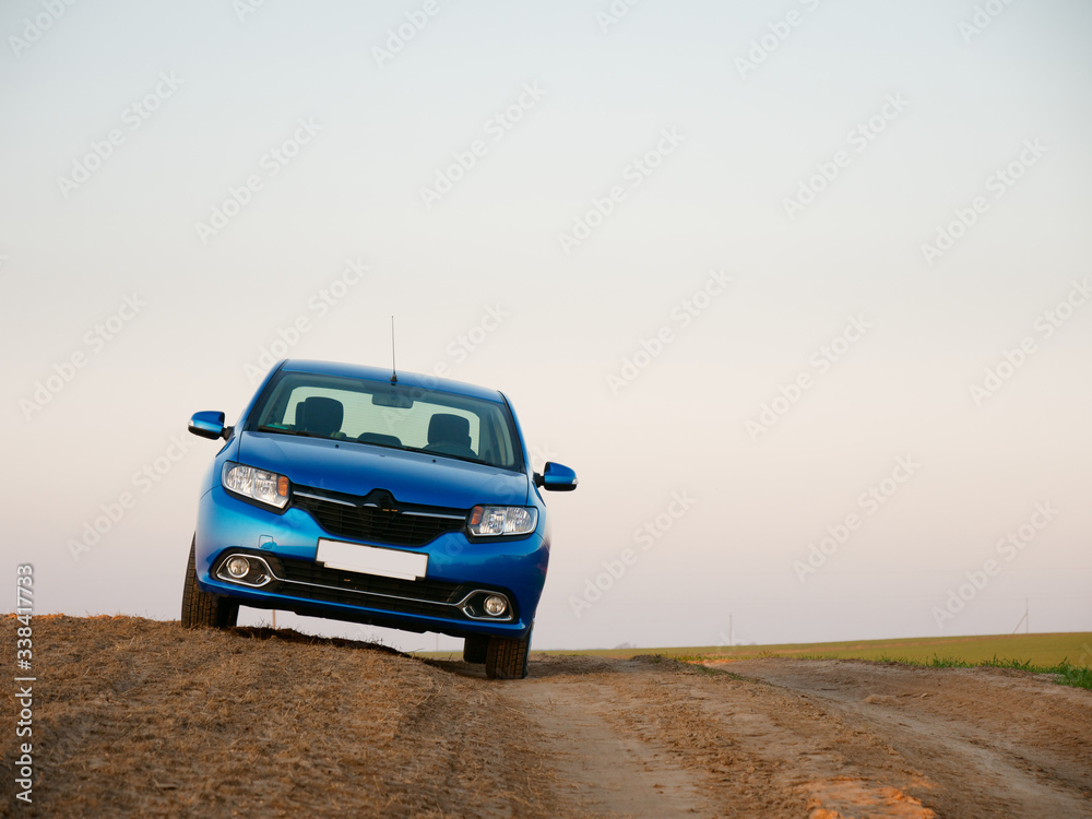 Belarus blue car in a field in spring at sunrise