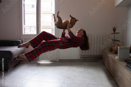 Papier peint Happy young woman levitation with dog