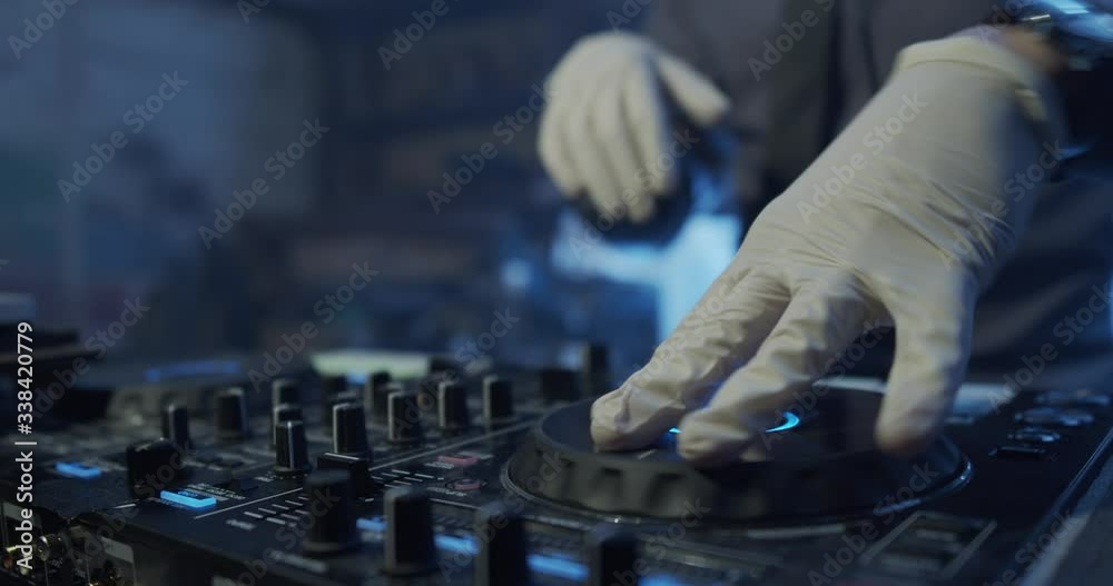 DJ plays live set and mixing music on turntable console at stage in the night club. Disc Jokey Hands on a sound mixer station at club party. DJ mixer controller panel for playing music and partying. DJ plays live set and mixing music on turntable console at stage in the night club. Disc Jokey Hands on a sound mixer station at club party. DJ mixer controller panel for playing music and partying.