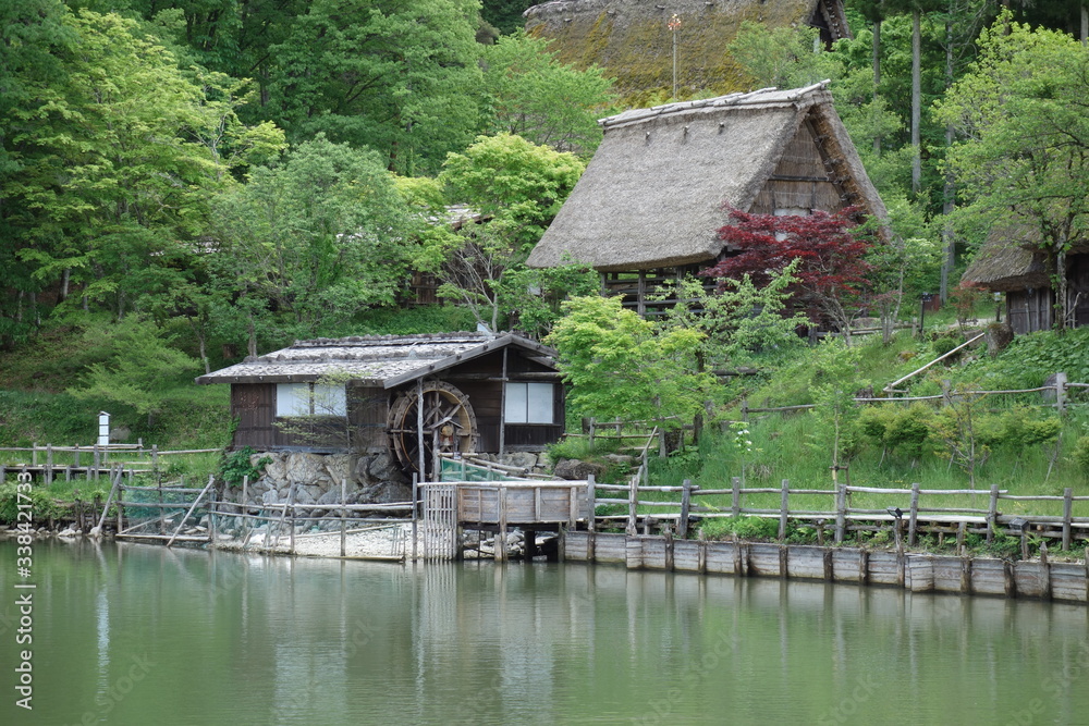 Japanese historical garden with watermill and riverbank