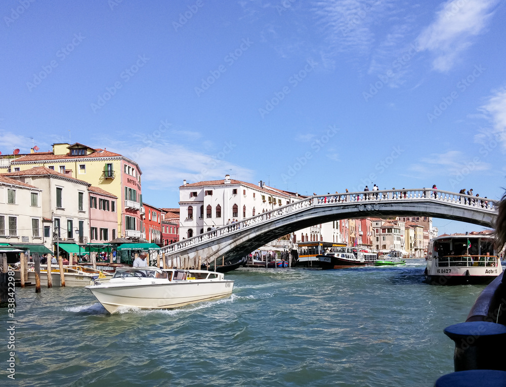 Tourists swim by river canal taxi and explore the local sights in Venice city in Italy.