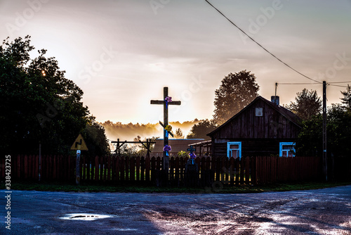 Sunrise in the old countryside with an orthodox wooden crucifix photo