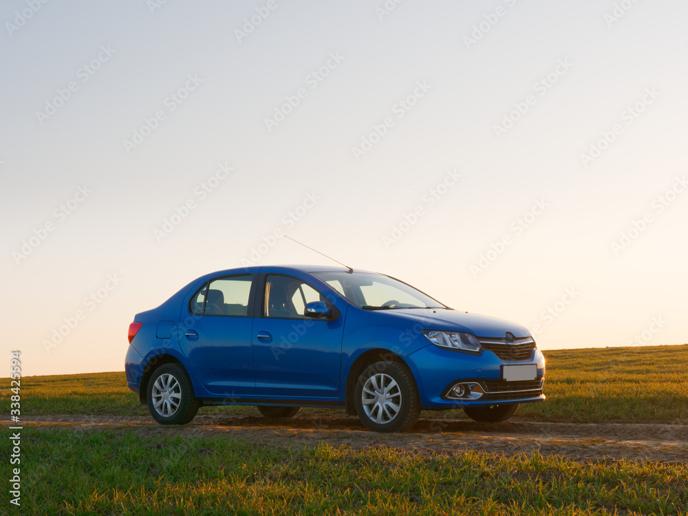 Belarus blue car in a field in spring at sunrise Belarus blue car in a field in spring at sunrise