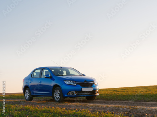 Belarus blue car in a field in spring at sunrise