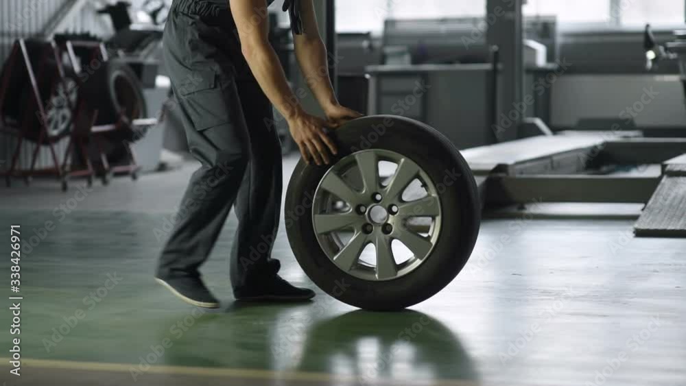 Mechanic holding a tire tire at the repair garage. replacement of winter and summer tires.