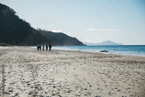 A group of people walking on an empty beach