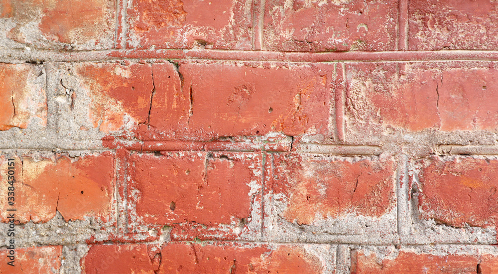 Obraz premium Red brick wall with cracks and scratches. Old background texture. Vintage house facade.