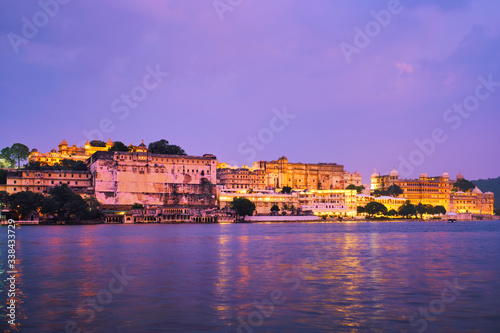 View of famous romantic luxury Rajasthan indian tourist landmark - Udaipur City Palace in the evening twilight with dramatic sky - panoramic view. Udaipur  India