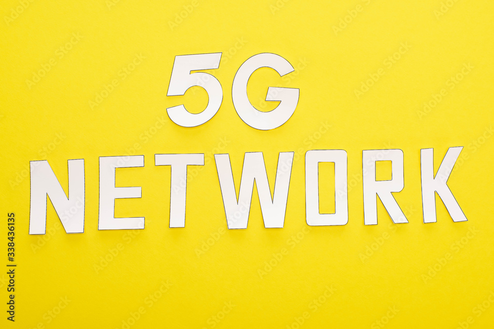 top view of white 5g network lettering on yellow background top view of white 5g network lettering on yellow background
