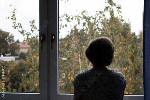  sad lonely old woman look next to  window allone depressed abandoned coronavirus stay home 