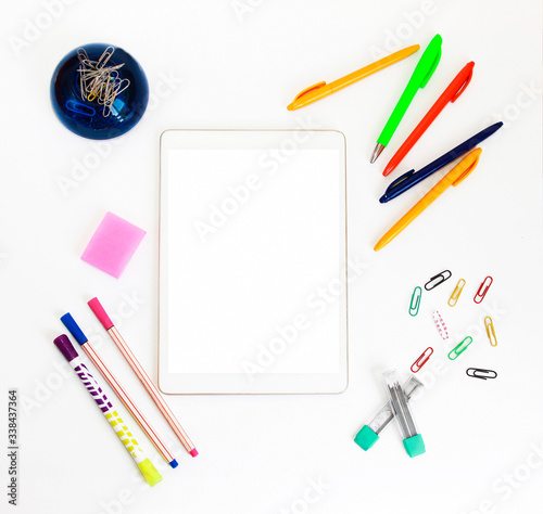 white electronic tablet and stationery, pens, paper clips, pencils and writing paper