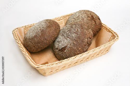 black bread with sunflower seeds in a basket white background