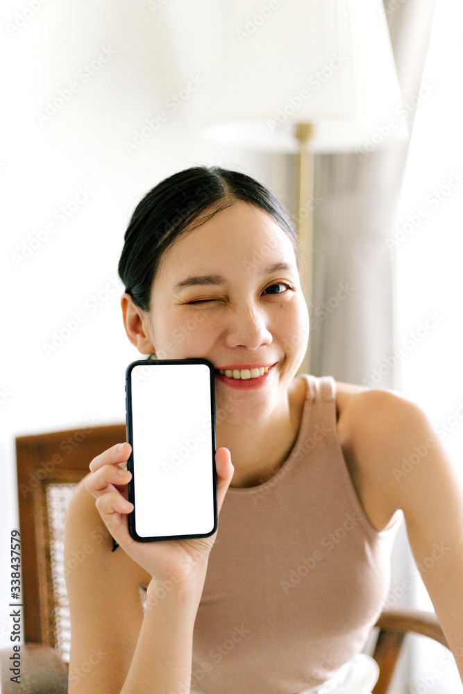 Asian cute woman is showing white blank smartphone screen on home studio background Asian cute woman is showing white blank smartphone screen on home studio background