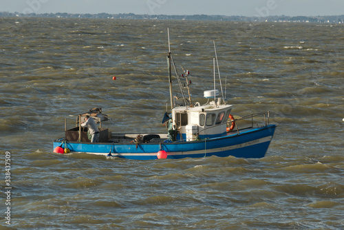 Marin pêcheur à bord de son bateau de pêche au travail pour relever ses filets, ses nasses, ses casiers et qui profite de la marée qui monte pour rapporter du poisson des crabes des homards et araigné