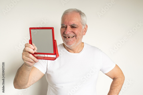 old man senior face closeup missing tooth smile proper tooth looking mirror overexposed not in focus