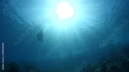 scuba divers coming down descending scenery underwater sun beams and rays sun shine silhouette scenery photo
