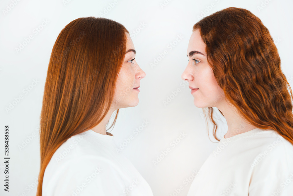 portrait of two redheaded young women looking at each other standing sideways on isolated white backgroung, close up portrait of two redheaded young women looking at each other standing sideways on isolated white backgroung, close up